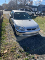 1997 Honda Civic with a K24 turbo engine, parked along a gravel path, showcasing its Japanese import features.