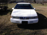 Front view of a well-maintained 1994 Mercury Cougar with low mileage, parked on grass.