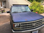 Blue 1993 Chevrolet truck with low mileage, good tires, and alloy rims parked in front of a house.