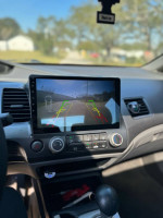 Interior view of a 2011 Honda Civic with a rearview camera display and climate controls.