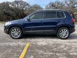 2011 Volkswagen Tiguan SEL 4Motion AWD parked in a lot with panoramic sunroof and stylish black exterior.