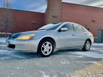 2005 Honda Accord LX in silver parked on a snowy surface, showcasing its clean exterior and sleek design.