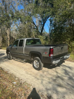 2001 Chevrolet Silverado 2500 4x4 on a dirt road with low mileage, showing rear view and solid build.
