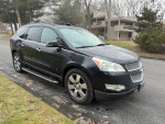 2009 Chevrolet Traverse LTZ FWD parked on a street, featuring leather interior and AWD capabilities.