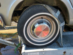 Close-up of a vintage Dodge B300 tire mounted on a trailer, showcasing its classic design and chrome hubcap.