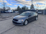 2015 Volkswagen Jetta SE in gray color parked outdoors, showcasing alloy wheels and clean condition.