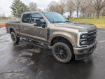 2023 Ford F250 Lariat Super Duty Crew Cab in black appearance package with tinted windows and Baja interior.