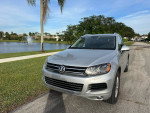 Silver Volkswagen SUV parked near a fountain in Florida, showcasing low mileage and great condition