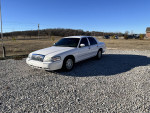 2008 Grand Marquis LS in white parked on gravel with clear blue sky, showcasing comfort and performance.
