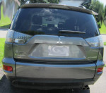 Rear view of a 2011 Mitsubishi Outlander XLS in gray, showcasing its design and features.
