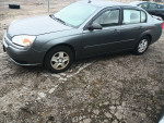 2005 Chevrolet Malibu LS in gray color, parked on gravel surface with 76,000 miles on the odometer.