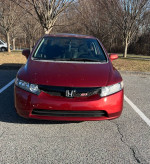 Front view of a red 2007 Honda Civic Si sedan parked in a driveway, highlighting its 4-door design.