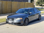 2007 Audi A4 2.0T FWD in gray parked on the street with a wooden fence in the background