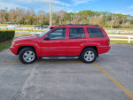 2001 Jeep Grand Cherokee Limited red SUV parked, featuring leather interior and power options.