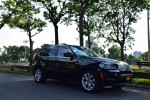 2013 BMW X5 xDrive35i AWD parked in a scenic park, showcasing its sleek design and all-wheel drive features.