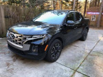 2022 Hyundai Santa Cruz SEL AWD in Phantom Black, parked on pavement in a wooded area.