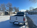 2014 Ford F250 Super Duty pickup truck parked in snowy neighborhood, showing rear view.