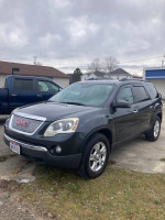 2011 GMC Acadia in good condition with V6 engine and tow package parked outside.