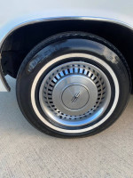 Close-up of a classic 1977 Cutlass Supreme wheel showcasing its mint condition and original design.
