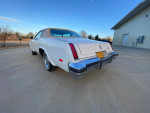 Rear view of a classic 1977 Oldsmobile Cutlass Supreme in mint condition, parked outdoors.