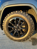Close-up of a black Jeep wheel with BF Goodrich All Terrain tires on a 2015 Jeep Cherokee Limited.
