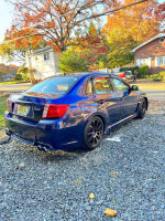 2013 Subaru WRX in blue, showcasing modified features like performance exhaust and sporty wheels