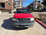 2003 Ford F-150 in red with minor cosmetic wear parked in a residential area, excellent daily driver.