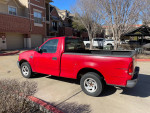 2003 Ford F-150 red truck parked, well maintained, minor cosmetic wear, ideal for daily driving or work.