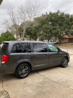 2017 Dodge Grand Caravan in gray color, parked, featuring dual sliding doors and a reliable family-friendly design.