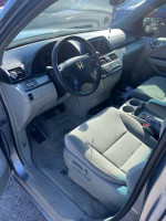 Interior view of a 2006 Honda Odyssey with gray seats and dashboard, showing mileage and condition details.