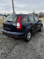2009 Honda CR-V in blue with all-wheel drive parked on gravel, showcasing its clean design and spacious trunk.