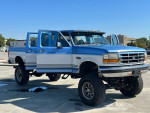 1995 Ford F350 Quad Cab 4WD with recent upgrades, Monster lift, and new tires parked outdoors
