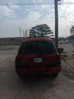 2003 Chevrolet TrailBlazer for sale with 127,000 miles, parked outside a repair shop.
