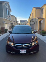 2014 Honda Odyssey EXL in excellent condition, parked in residential area with clear sky.