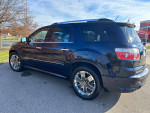 Side view of a 2012 GMC Acadia Denali in excellent condition with chrome wheels and a black exterior.