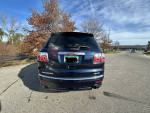 Rear view of a 2012 GMC Acadia Denali in excellent condition, parked on a suburban street.
