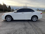 Side view of a 2007 Acura TSX in white with low mileage, featuring stylish alloy wheels.
