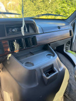 Interior view of a 1997 Dodge 3500 passenger van with clean dashboard and cup holders