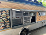 1997 Chevrolet P30 catering food truck with menu display and equipped kitchen for food service.