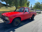 1983 Toyota Pickup truck in excellent condition, red color, showing mechanics and single owner history, parked outdoors.