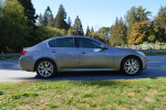 2009 Infiniti G37 Sport Sedan in gray parked on a road surrounded by greenery.