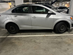 2015 Chevrolet Sonic LT FWD in a parking garage, silver color with clean lines and minimal wear.
