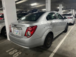 2015 Chevrolet Sonic LT parked in a garage, showcasing its silver exterior and clean design.
