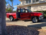 1998 Dodge Ram 1500 SLT V8 Magnum with open doors, low mileage, and a tow hitch in a driveway.