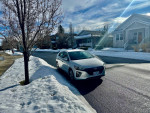 2019 Hyundai Ioniq Electric parked on snowy street, showcasing low mileage and pristine condition.