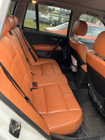 Interior view of 2006 BMW X3 showing spacious rear seating with orange leather upholstery.