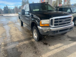 1999 Ford F-350 Super Duty black truck with four doors, visible misfire issue for sale at $2,600 cash.