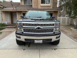 2015 Chevrolet Silverado 1500 LT front view with chrome grille in residential driveway