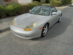 1998 Porsche Boxster convertible in silver, featuring automatic transmission and 80k miles, parked on the street.