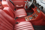 Interior of a pristine 1989 Mercedes-Benz 560SL with burgundy leather seats and classic dashboard features.